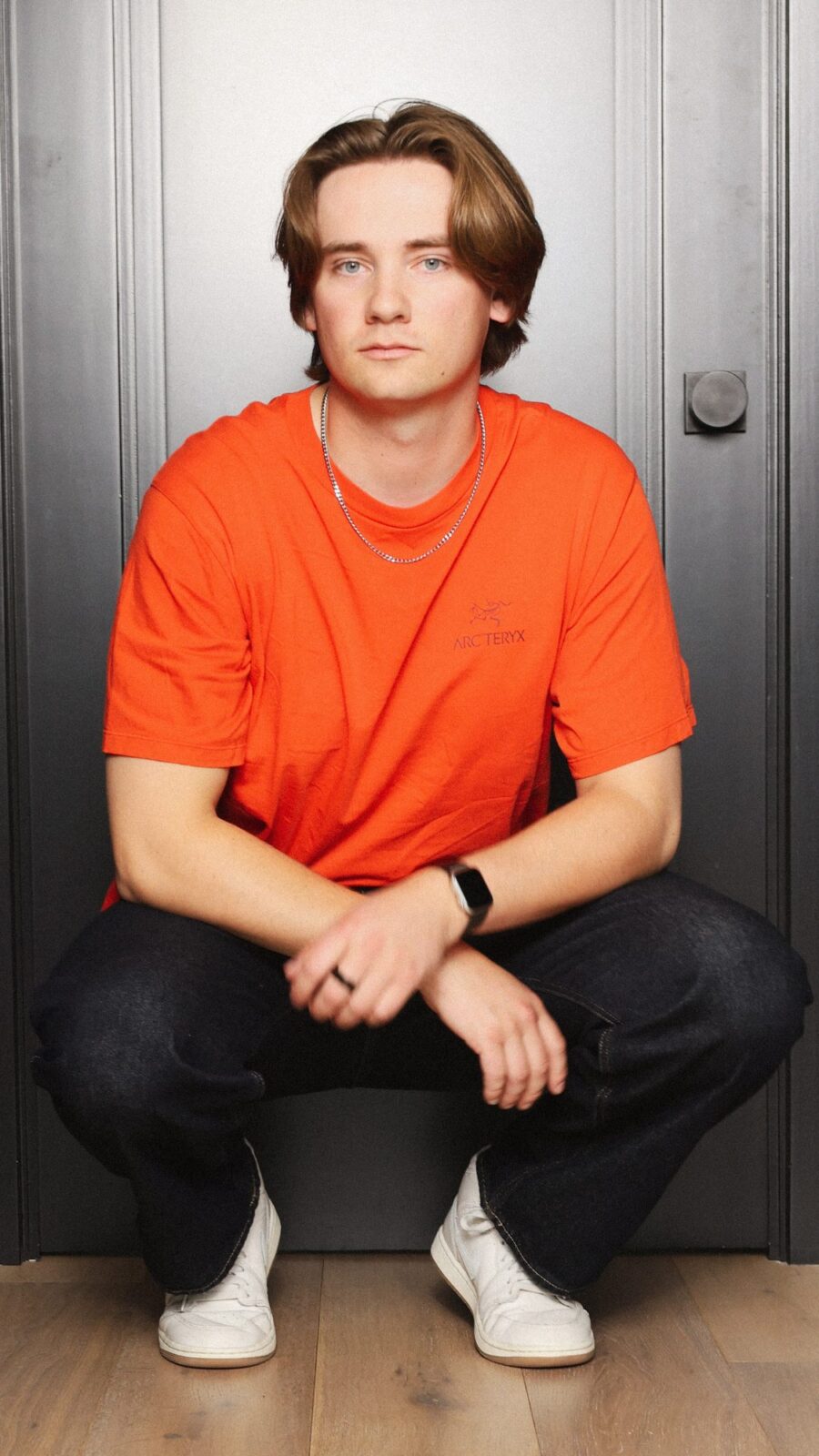 Hans Groover, Toronto house producer – crouched portrait, orange tee